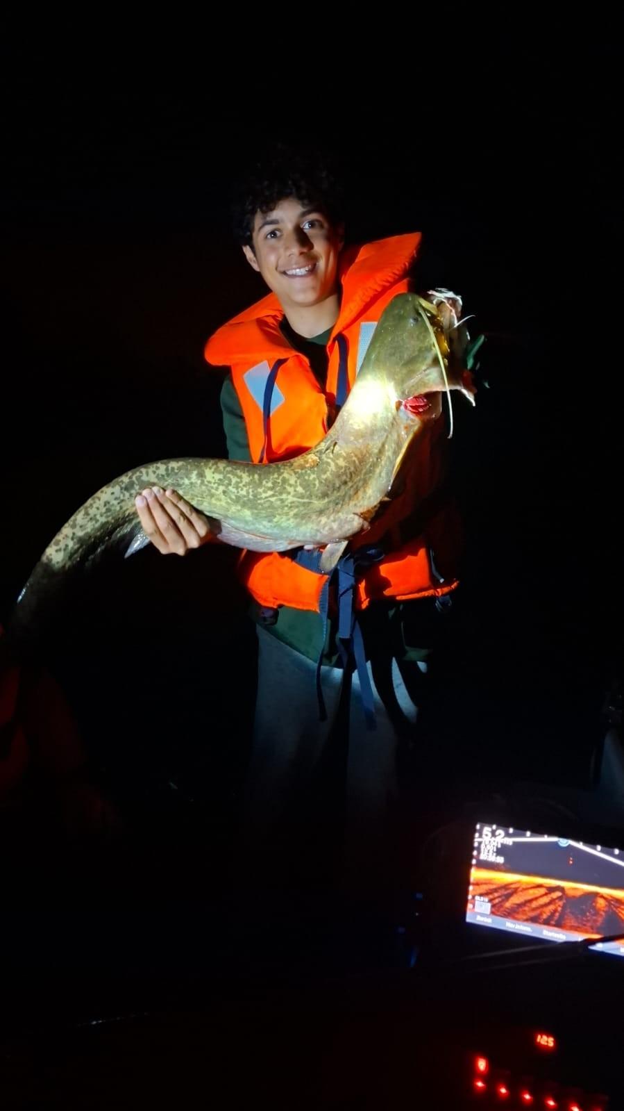 Jungfischer, der einen Wels hält